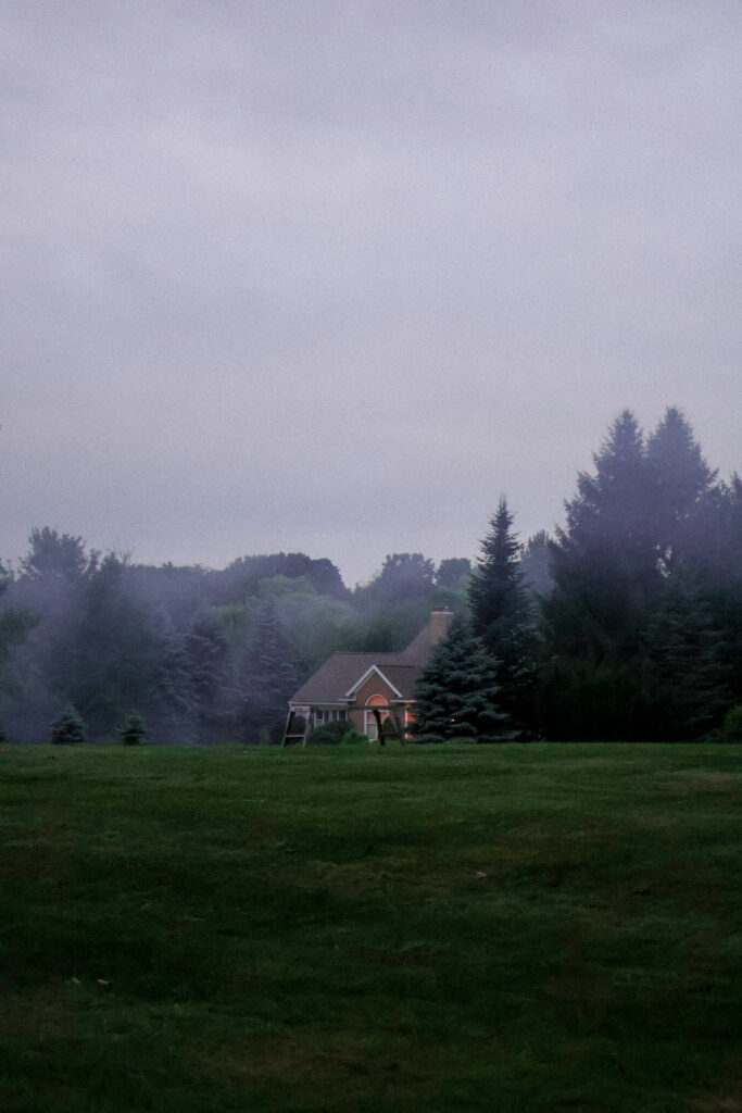 Vertical smokey landscape with a house in the distance